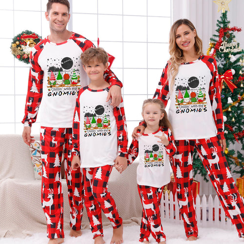 A family of four wearing matching Christmas-themed long-sleeve pajamas with a white front and red-and-black buffalo plaid sleeves and pants. The pajama design features a gnomes graphic with the text 'FIND ME A GNOOME!'.
