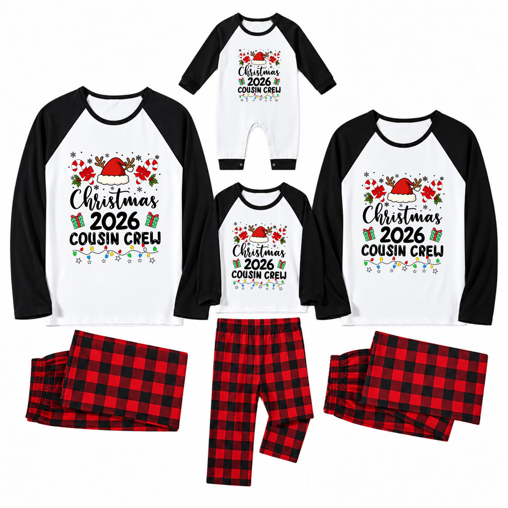 A family Christmas pajama set displayed on a white background, including long-sleeve raglan shirts and matching plaid pants in three sizes, with one baby bodysuit. The shirts are white with black sleeves and a colorful 'Christmas 2026 Cousin Crew' graphic, paired with red and black plaid pants.