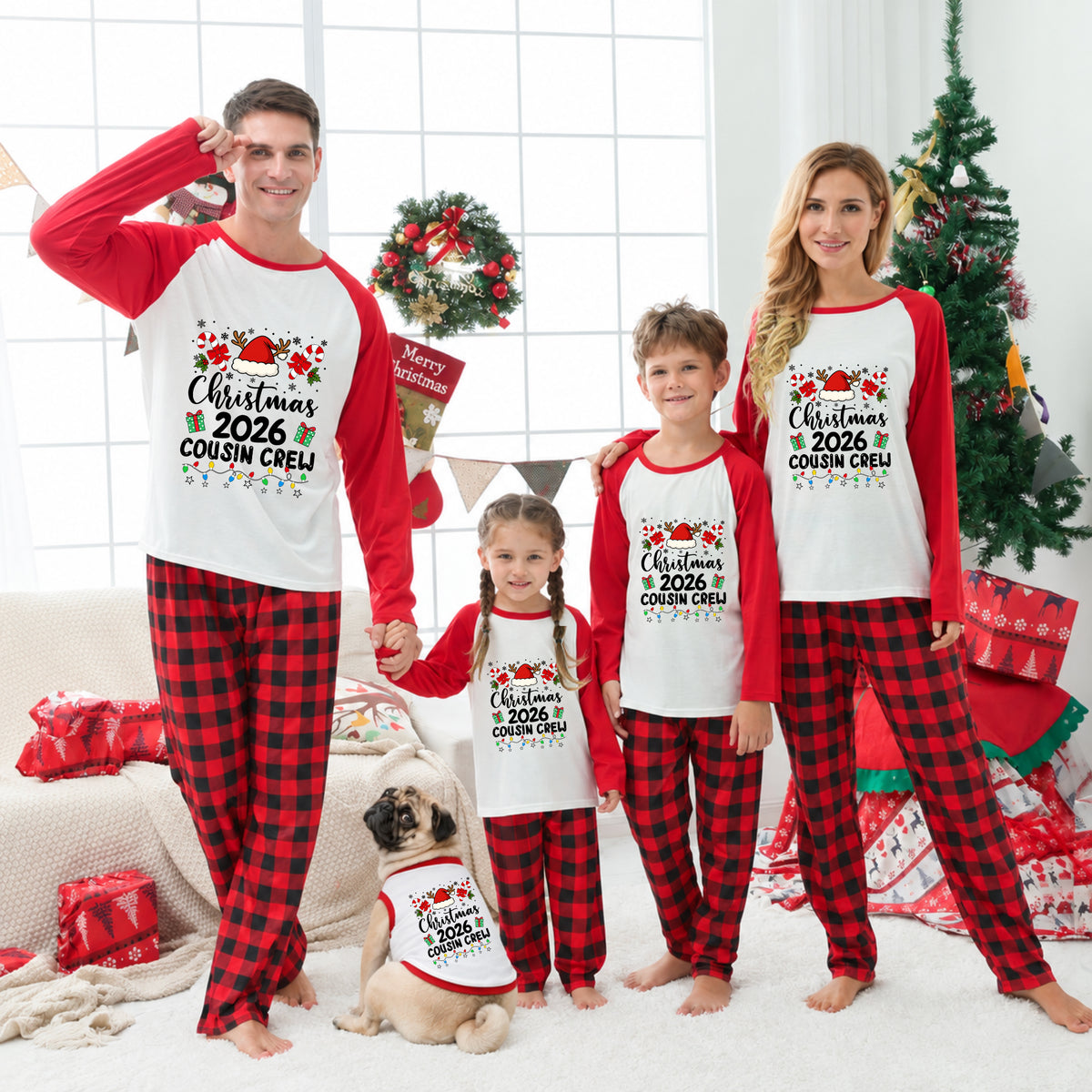 A family of four and a dog wearing matching Christmas-themed pajamas in a living room decorated for the holidays. The pajamas are white with red long sleeves and red-and-black buffalo plaid pants, featuring a graphic that reads 'Christmas 2026 Cousin Creep'.