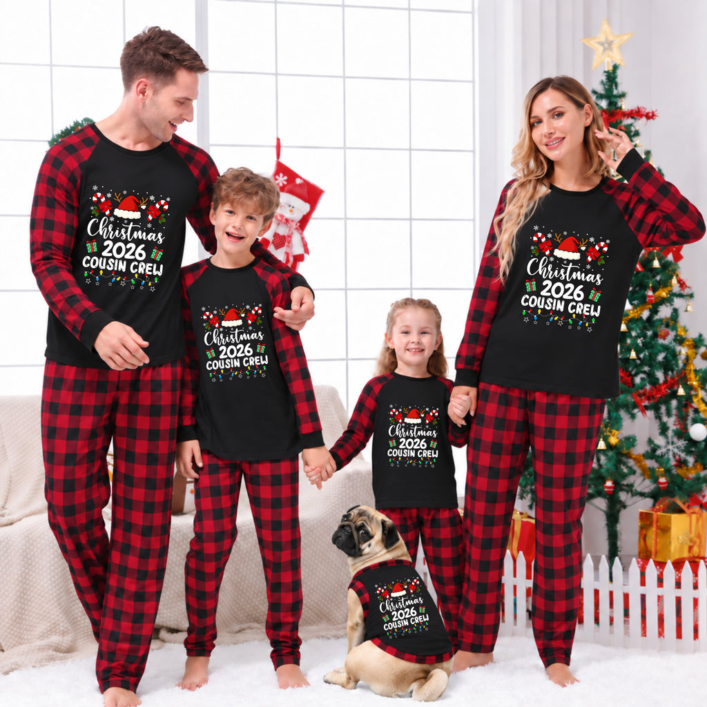 A family of four and a dog wearing matching black and red plaid Christmas pajamas with 'Christmas 2026 Cousin Creep' printed on the front, posed in a festive living room with a Christmas tree and stockings in the background.