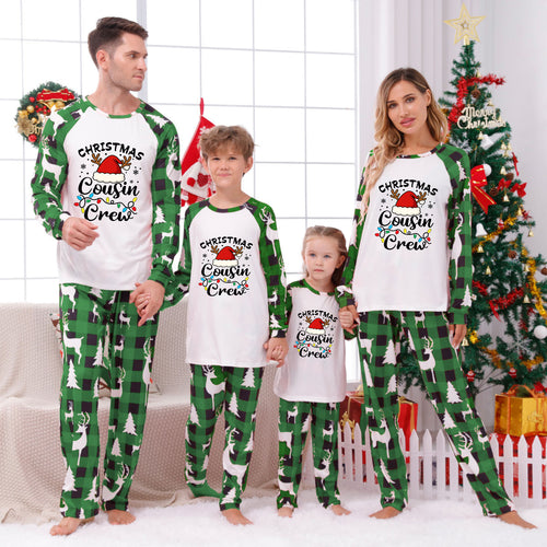 Three matching family Christmas pajama sets in different sizes, featuring cream-colored long-sleeve tops with a black-and-white striped Christmas tree graphic and patterned pants. The pants have holly and pinecone motifs, with the largest set having dark brown pinecones and the smaller sets having dark brown pinecones with green holly accents.