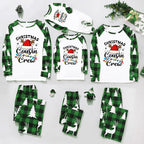 A coordinated Christmas family pajama set arranged on a light gray background, including long-sleeve tops and matching pants in green plaid and white with holiday graphics such as Santa hats, trees, reindeer, and the text 'Christmas Cousin Crew.'.
