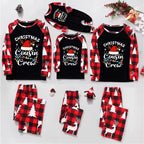 A matching family Christmas cousin crew pajama set displayed flat on a white background, including long-sleeve shirts and pants for different sizes. The shirts are black with red and black buffalo plaid sleeves and a white graphic reading 'Christmas Cousin Crew' with a Santa hat and holiday lights.