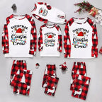 Three matching Christmas cousin crew pajama sets arranged on a light gray background, including long-sleeve raglan shirts and plaid pants in red, black, and white holiday prints. The shirts read 'Christmas Cousin Crew' with a Santa hat and colorful holiday accents, and the pants feature tree and reindeer motifs.