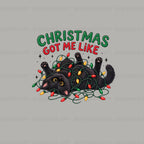A festive graphic design featuring a black cat tangled in Christmas lights with the text 'CHRISTMAS GOT ME LIKE' above it, shown on a light gray background with repeated 'puglypack.com' watermarks.