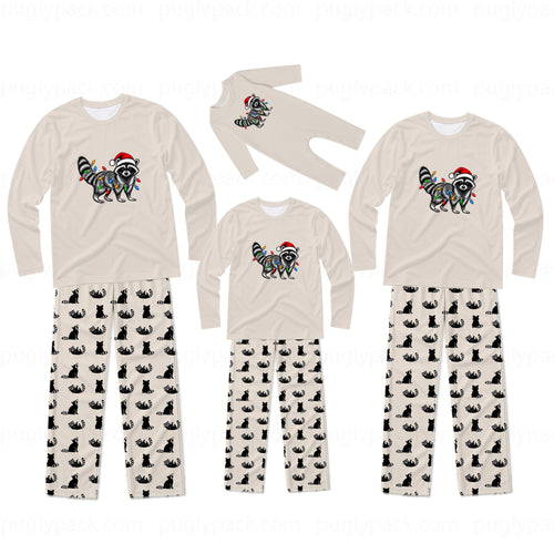 A matching family pajama set displayed on a white background, including three sizes of long-sleeve shirts and pants. The shirts are cream-colored with a raccoon graphic decorated with colorful Christmas lights and a red Santa hat.