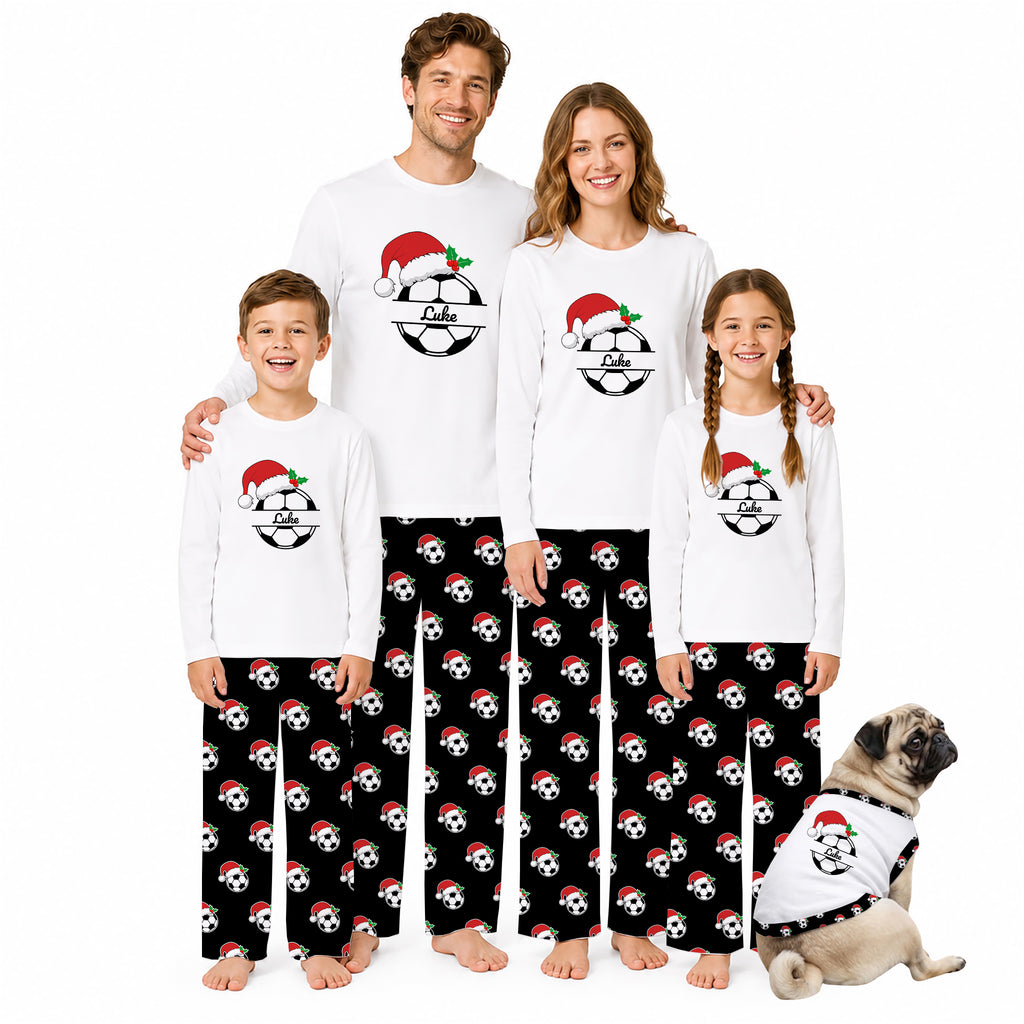 A family of four and a dog wearing matching white long-sleeve pajamas with a black soccer ball pattern and Santa hats, posed against a plain white background.