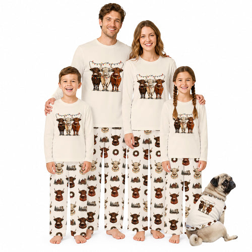 A family of four wearing matching Christmas-themed pajamas stands together on a White background, with a small dog in a matching pajama set sitting beside them. The pajamas are Cream-coloRed with a graphic of four cows at the top and a repeating pattern of brown cows and holiday motifs below.