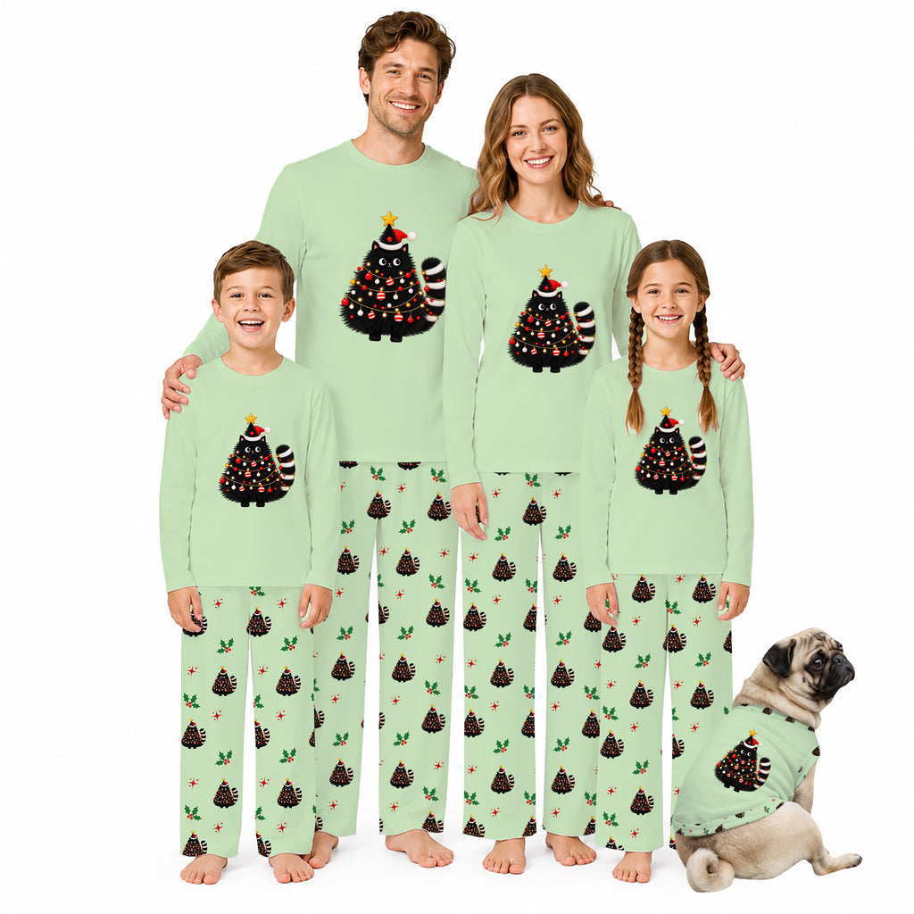 A family of five wearing matching light green Christmas-themed pajamas stands together on a white background, with a small pug dog wearing a matching pajama set beside them. The pajamas feature a black Christmas tree graphic with red ornaments and a striped tail on the chest, and a repeating pattern of dark pine trees with small red and green accents on the pants.