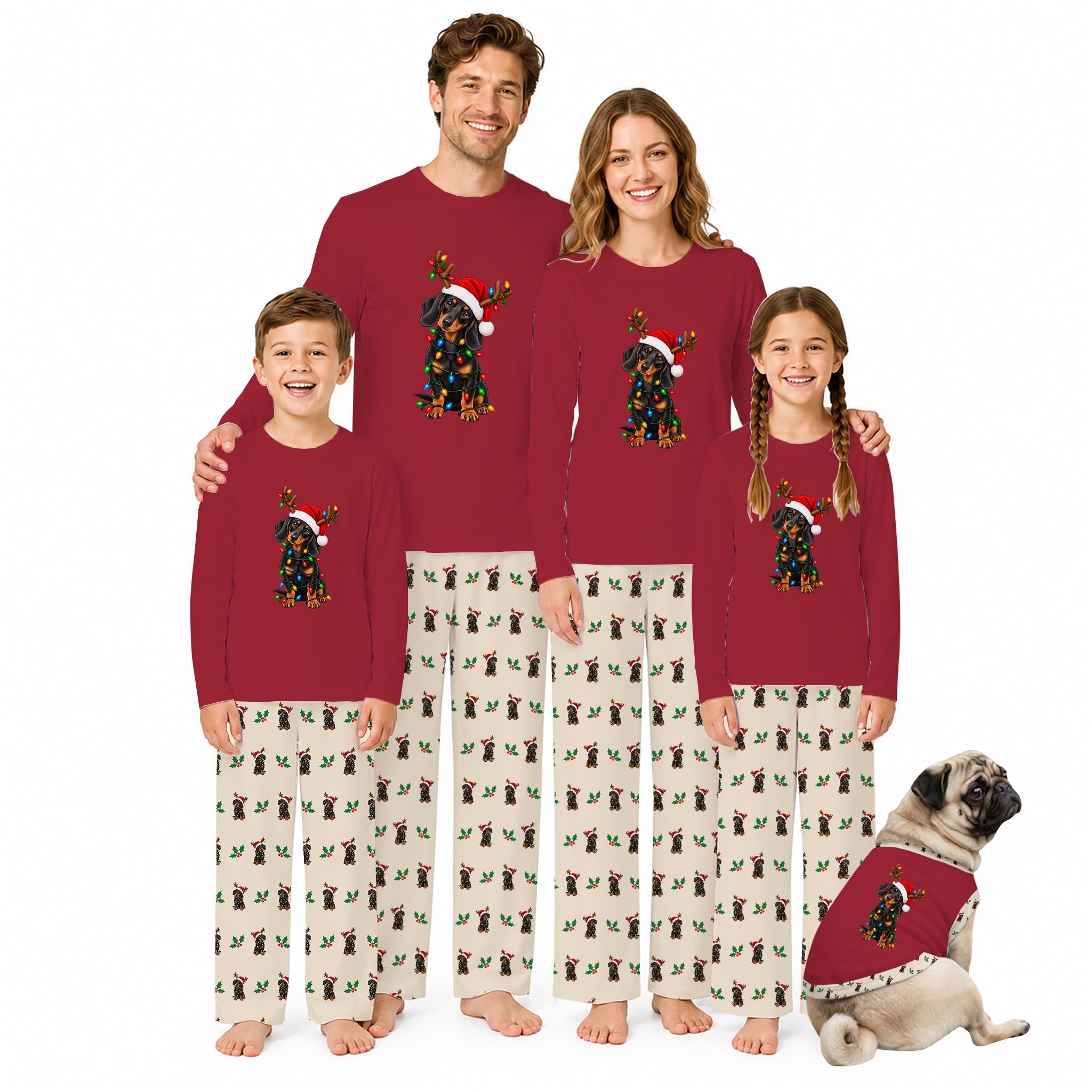 A family of four and a dog wearing matching Christmas pajamas against a plain White background. The pajamas are deep Red long-sleeve tops with a Black dog wearing a Santa hat graphic, paiRed with Cream pants featuring a repeating Black dog print.