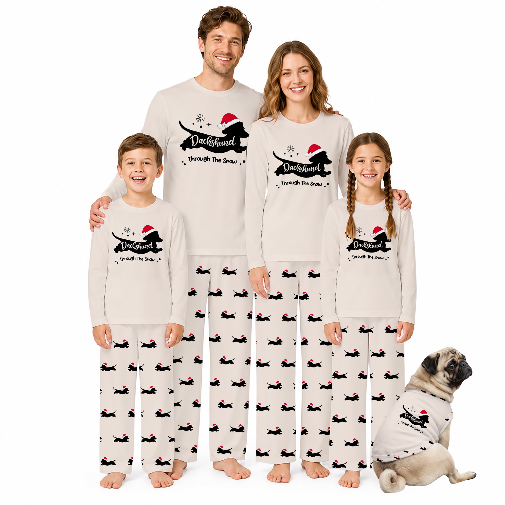 A family of four and a dog wearing matching holiday-themed long-sleeve pajamas with a Black silhouette graphic, Red Santa hat, and 'Through the Snow' text, posed against a plain White background.