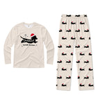 A two-piece Christmas pajama set on a White background, featuring a long-sleeve Cream shirt with a Black dachshund graphic wearing a Santa hat and the text 'Dachshund Through The Snow,' and matching Cream pants with a repeating pattern of Black dachshunds wearing Red Santa hats.