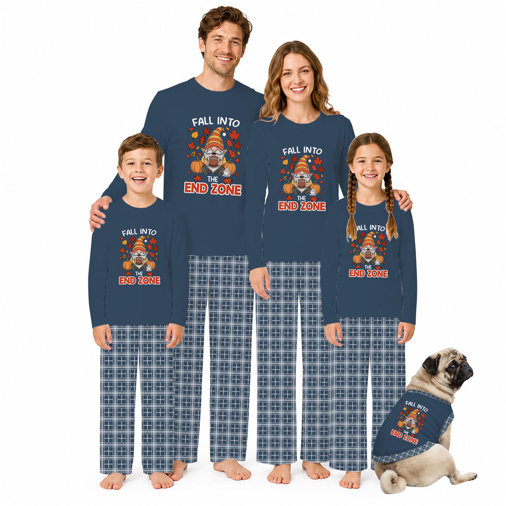A family of four and a dog wearing matching long-sleeve pajamas with a Thanksgiving-themed graphic that reads 'FALL INTO END ZONE' and plaid pants, posed against a plain white background.