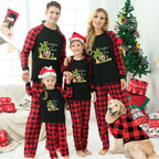A family of four wearing matching Black and Red plaid Christmas pajamas with a palm tree beach graphic, standing in a decorated living room with a Christmas tree, gifts, and a golden retriever dog wearing a matching shirt.