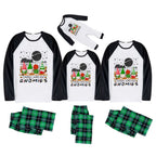 Three matching family-sized holiday pajama sets shown on a white background, including raglan long-sleeve shirts and green plaid pants. The shirts have a white front with black sleeves and a Christmas gnome graphic with the text 'I Chillin' with my GNOMIES'.