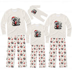 A matching family Christmas pajama set with long-sleeve shirts and pants in cream white. The shirts feature a cute raccoon wearing a Santa hat and holding a red mug with the text 'Cute But FERAL'.