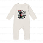 An off-white long-sleeve baby romper with a festive raccoon graphic on the chest. The graphic features a raccoon wearing a red Santa hat and holding a red mug, surrounded by the text 'Cute But Feral' in black script and print.