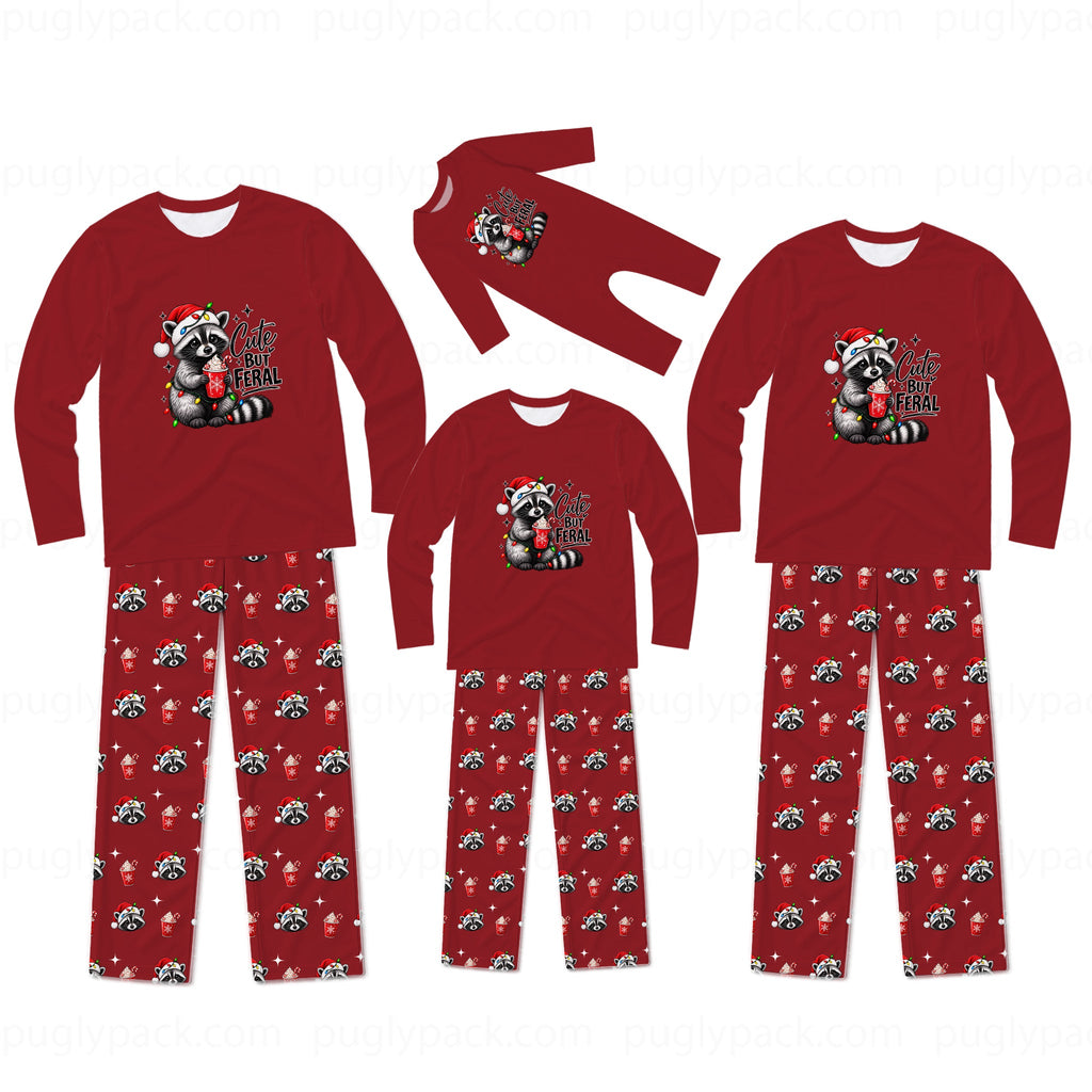 Three sizes of matching Christmas family pajamas shown on a white background, including long-sleeve shirts and pants. The pajamas are red with a raccoon wearing a Santa hat graphic on the chest and red pants featuring a repeating pattern of the same raccoon design.