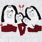 A coordinated family Christmas pajama set laid out on a White textuRed background, including three Black-and-White raglan long-sleeve shirts with polar bear graphics and text, matching Red-and-Black plaid pants, a Red reindeer antler headband, and small Red holiday accents.