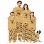 A family of four and a dog wearing matching tan and brown western-print pajamas with a cowboy riding a cactus graphic and the text 'Giddy Up Pick Up Your Feet' on a white background.