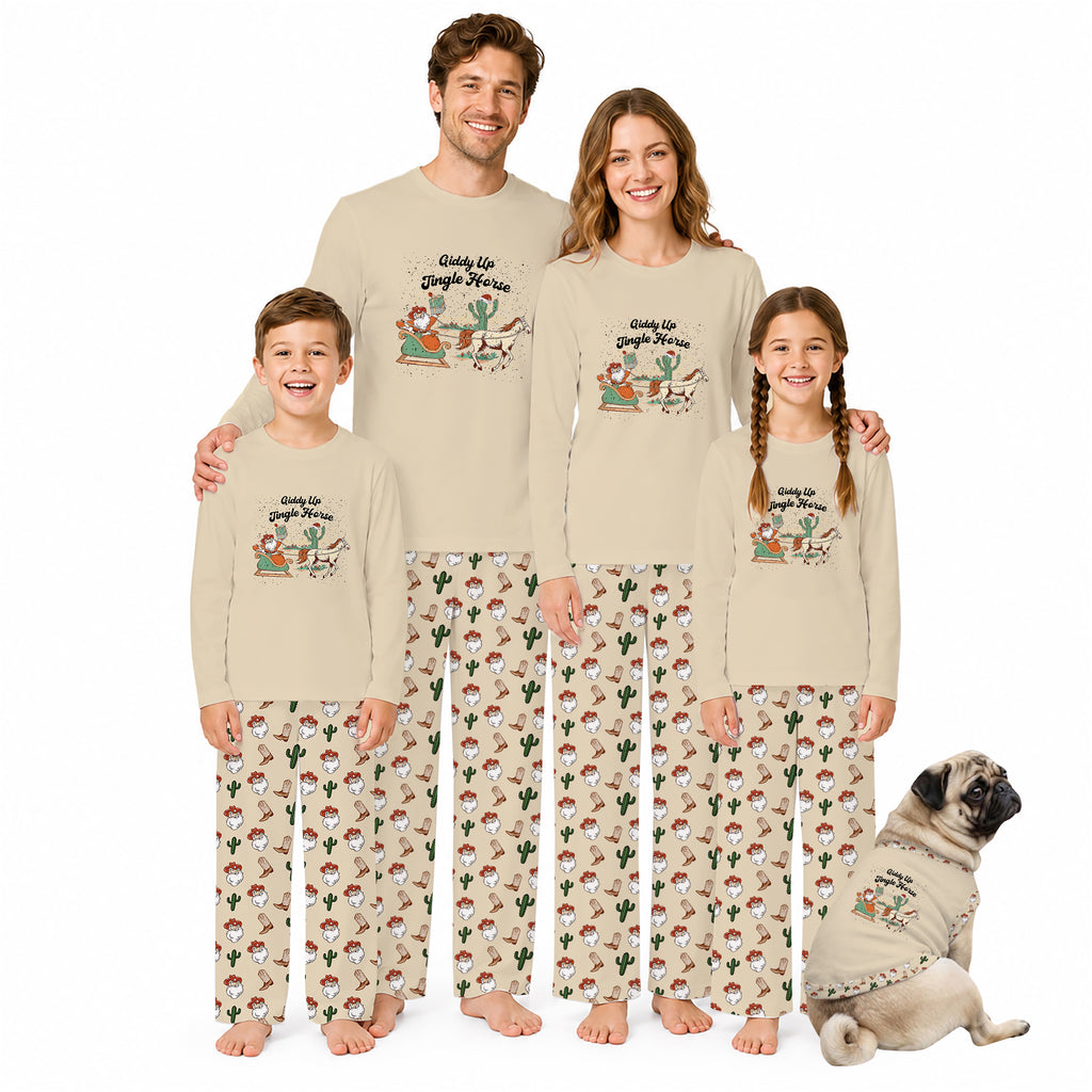 A family of four wearing matching beige pajamas with a cactus and Santa graphic on the shirts and a cactus print on the pants, standing barefoot against a white background with a small dog in a matching pajama outfit beside them.