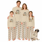 A family of four wearing matching beige pajamas with a cactus and Santa graphic on the shirts and a cactus print on the pants, standing barefoot against a white background with a small dog in a matching pajama outfit beside them.