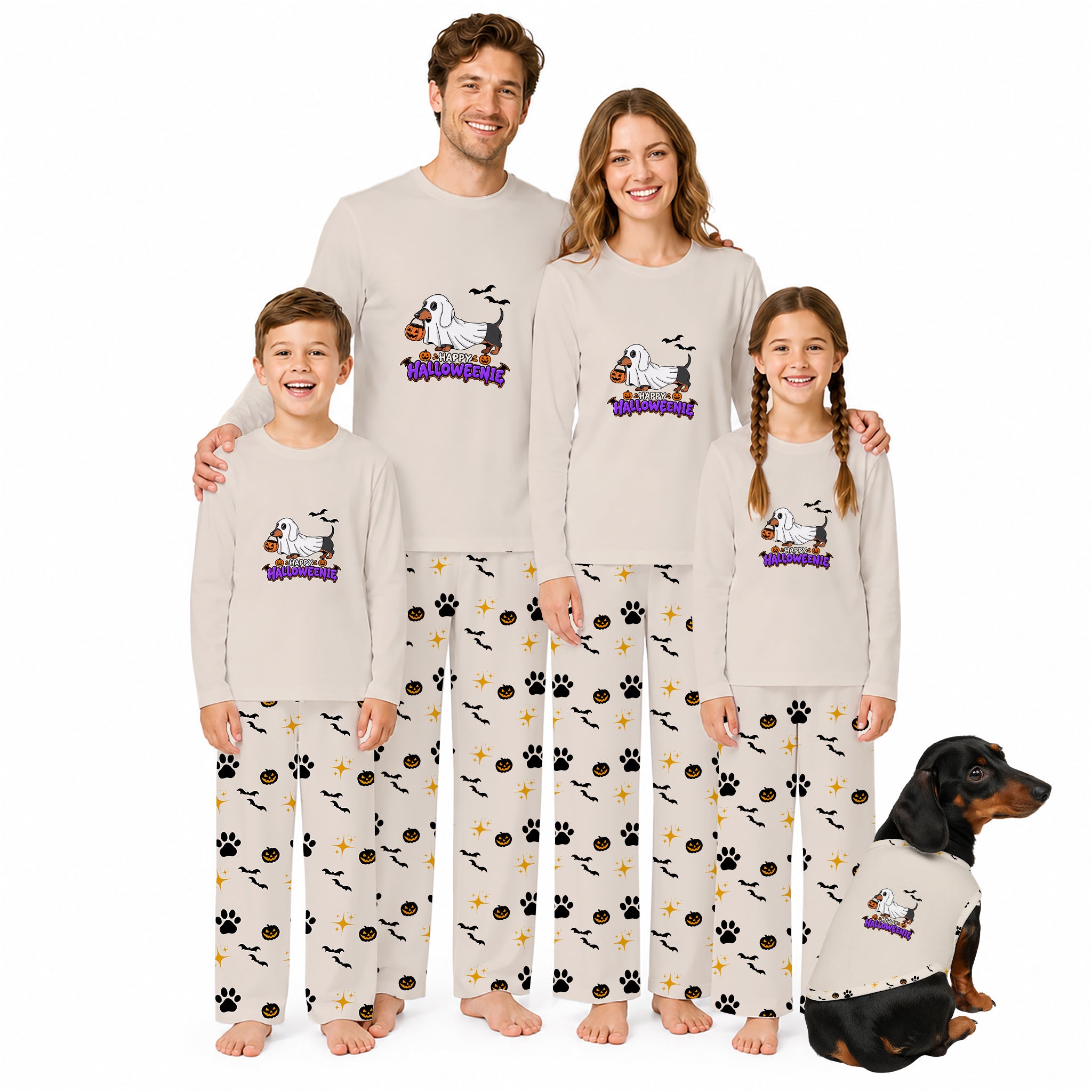 A family of four and a dog wearing matching long-sleeve pajamas with a cartoon dog graphic and 'Halloween' text on the chest, plus patterned pants with paw prints, bats, and treats, posed against a plain White background.