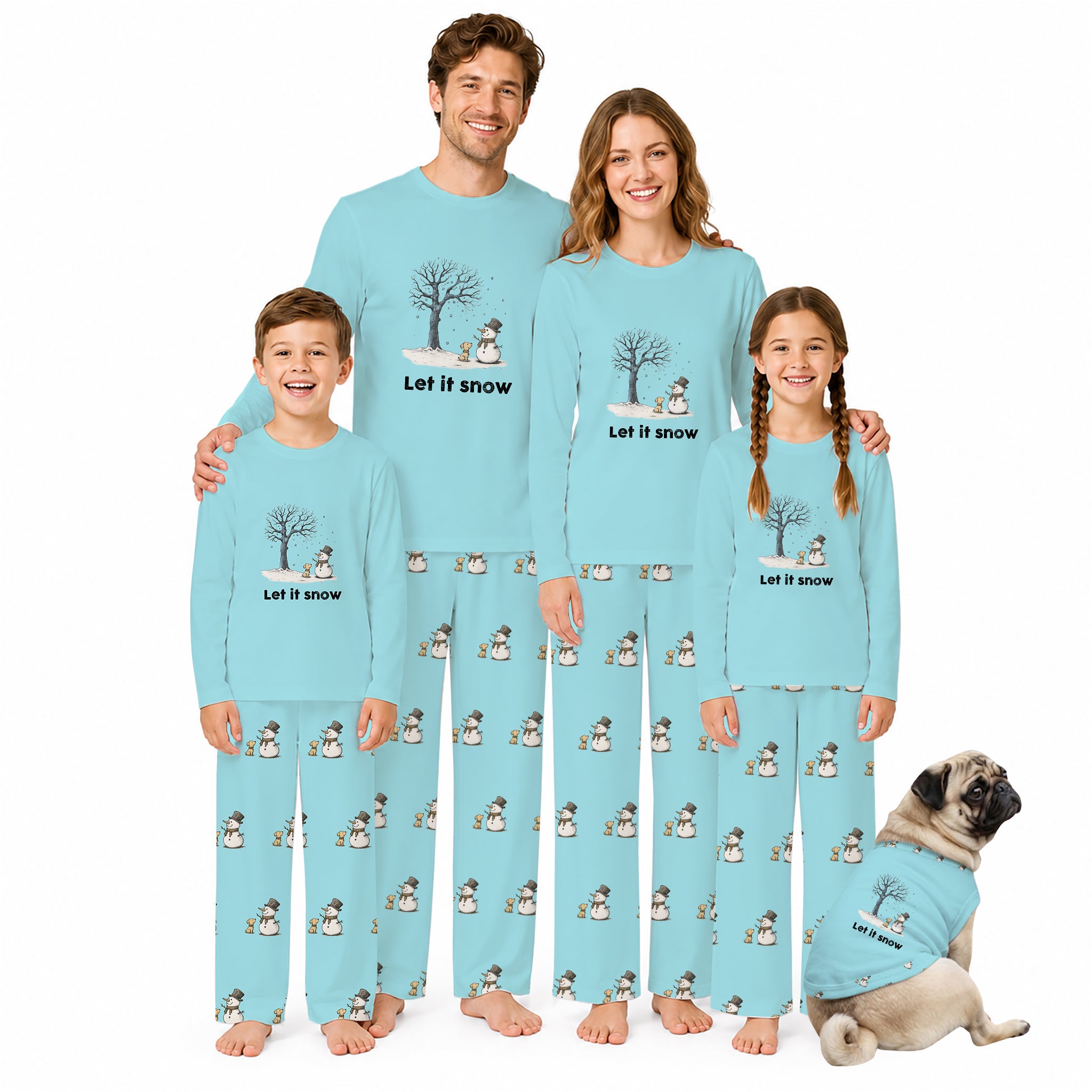 A family of four wearing matching light Blue pajamas with a winter tree and snowman print, standing together on a White background with a small dog wearing a matching pajama set beside them.