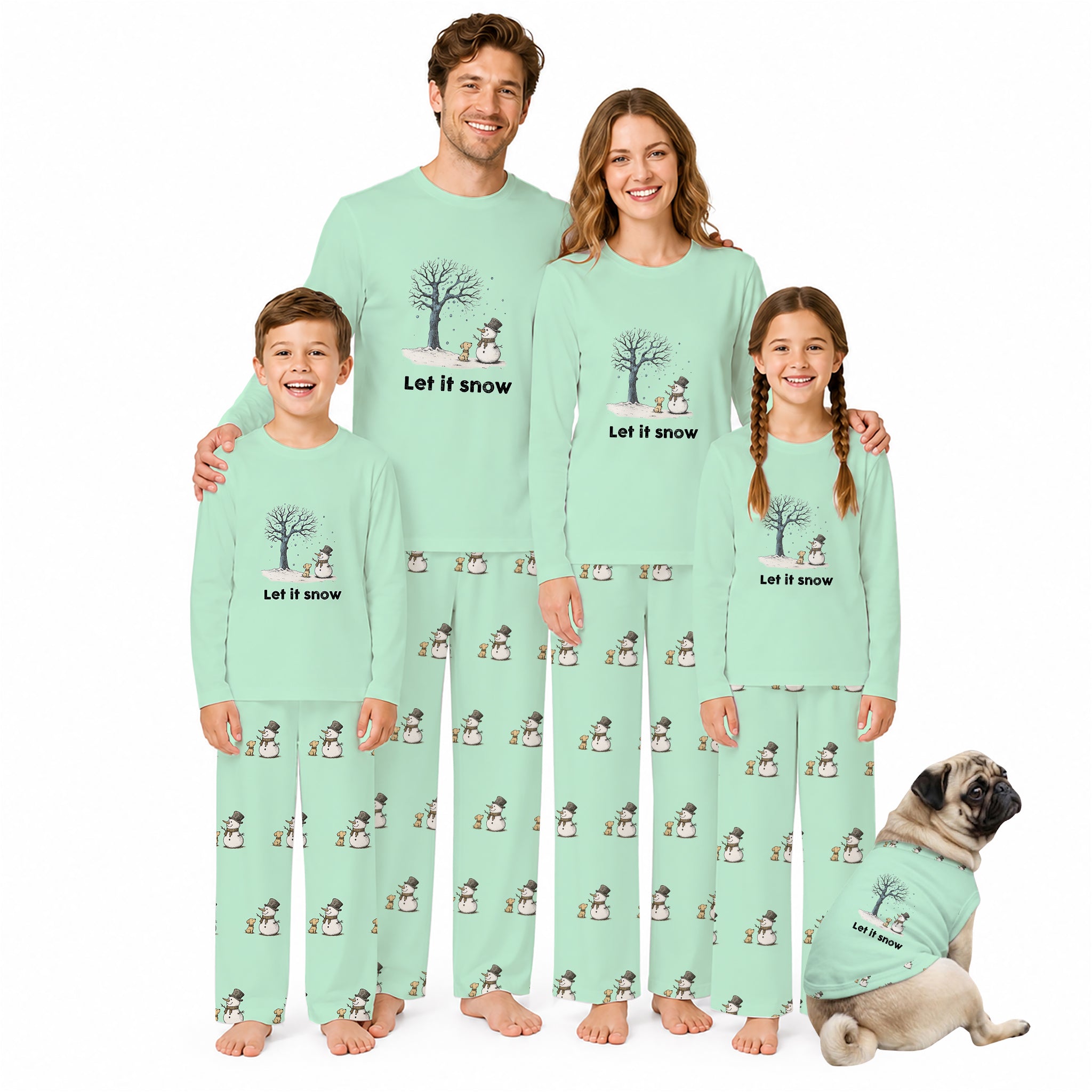 A family pajama set shown on four people and a dog against a plain White background. The matching long-sleeve pajamas are Mint Green with a repeating snowman print and the words 'Let It Snow' on the chest.