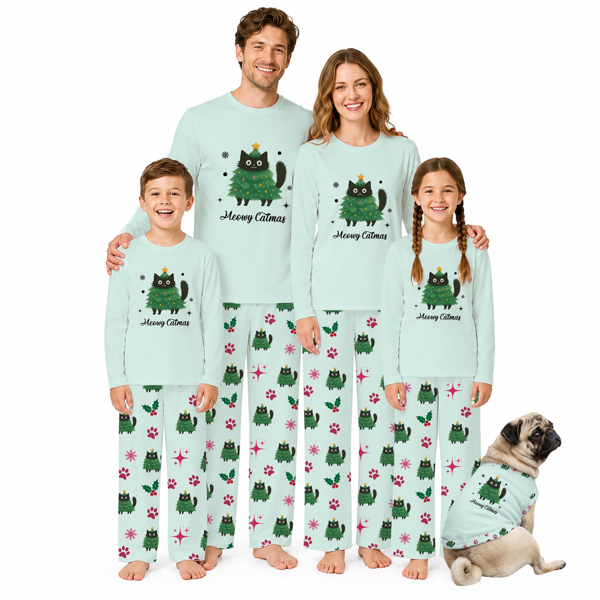 A family of four wearing matching light Mint Green pajamas with a Green Christmas tree cat graphic and paw-print pattern, standing barefoot against a White background, with a small matching dog sitting beside them.