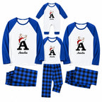 A matching family pajama set displayed on a white background, including long-sleeve raglan shirts and plaid pants in blue and black. The shirts are white with royal blue sleeves and collar, featuring a customizable graphic with a large letter 'A', a Santa Claus reindeer, and the name 'Amelia'.