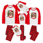 A coordinated Christmas pajama set shown on a white background, including long-sleeve raglan tops and matching plaid pants in red and black buffalo plaid, each top featuring a festive Raccoon-themed graphic.