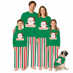 A family of five wearing matching Christmas-themed long-sleeve pajamas stands together on a white studio background, with a small dog wearing a matching pajama set beside them. The pajamas are bright green with red and white vertical stripes and a Santa Claus graphic with a personalized name label.