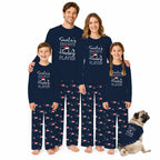 A family of four wearing matching Navy Blue pajamas with White text reading 'Santa's Favorite Hockey Player' stands barefoot against a White background, with a small pug dog sitting at their right. The pajama set includes long-sleeve tops and patterned pants with repeated hockey motifs.