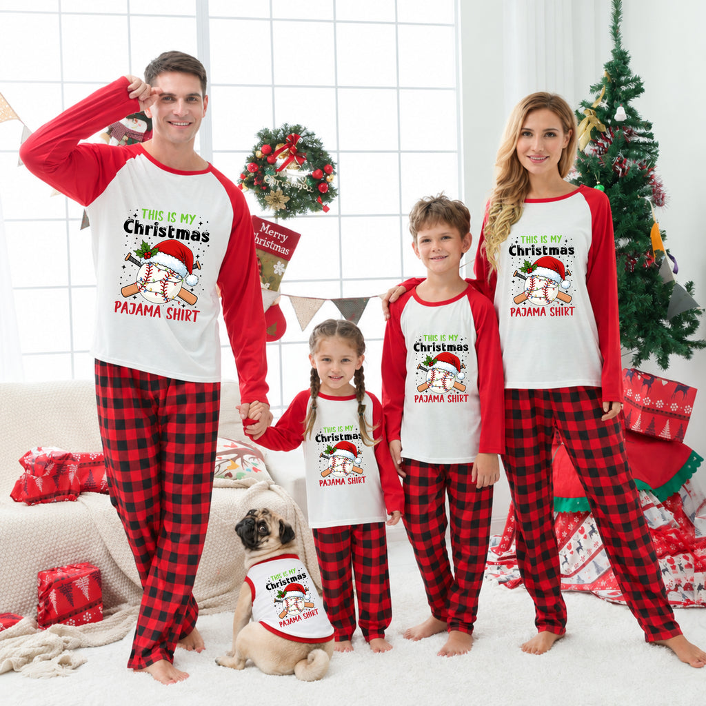 A family of four and a pug wearing matching Christmas pajama sets in a decorated living room. The pajamas feature a white and red raglan design with a cartoon penguin wearing a Santa hat and the text 'THIS IS MY Christmas PAMA SHIRT' above red and black buffalo plaid pants.